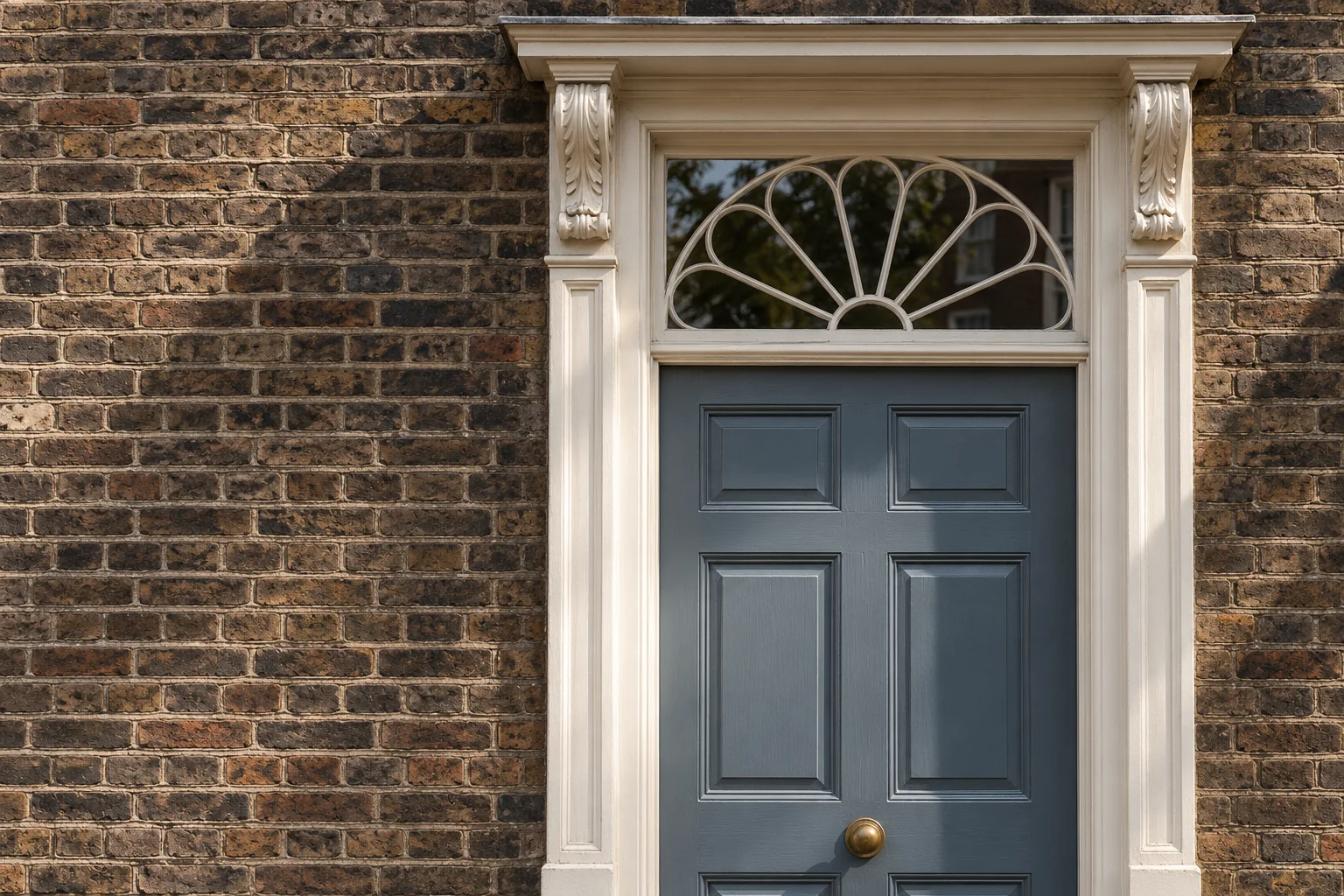 Painted Georgian doorcase with carved brackets, a panelled timber door and fanlight